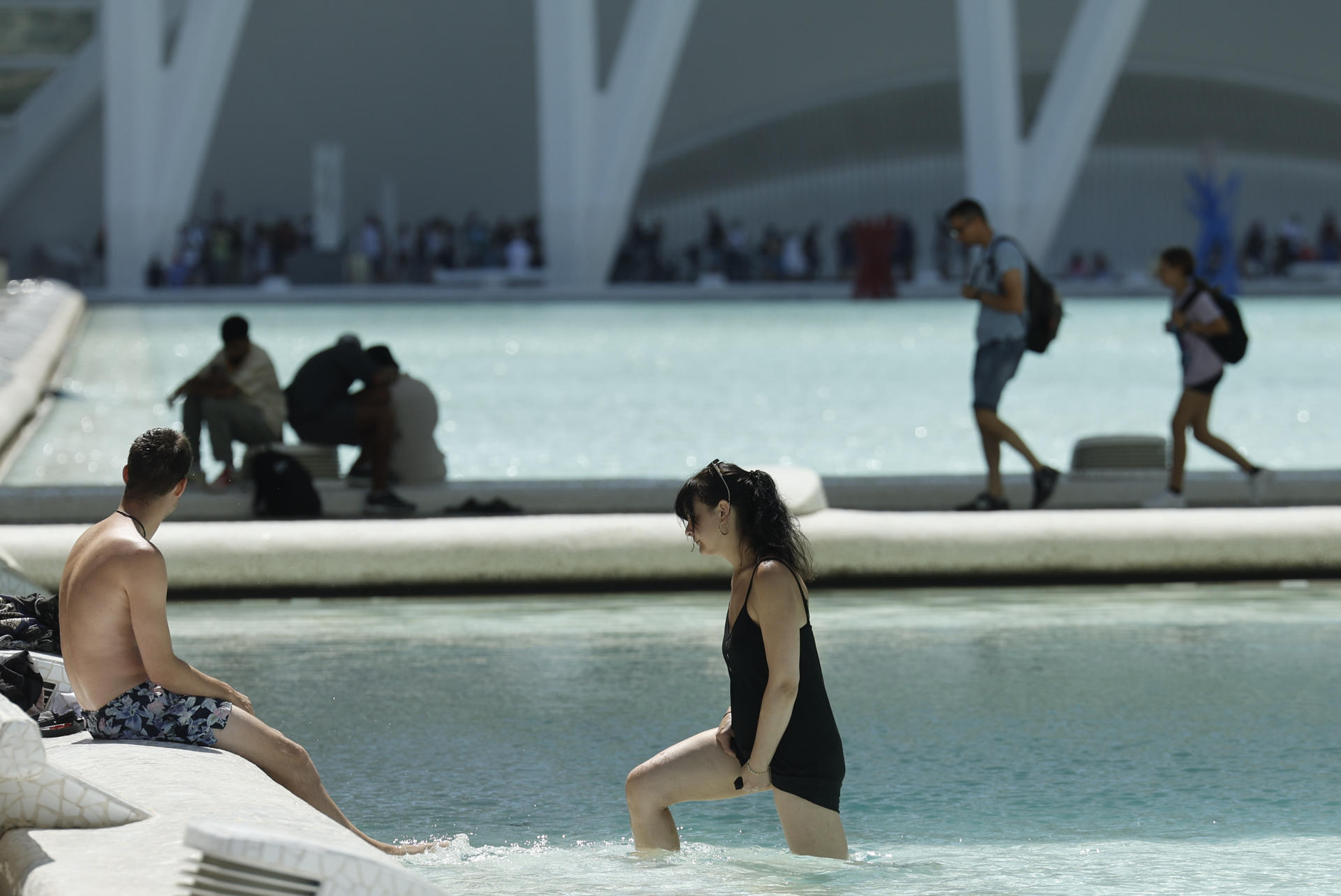 Varias personas se refrescan en las fuentes de la Ciudad de las Artes y las Ciencias de Valencia, este viernes. EFE/ Kai Försterling
