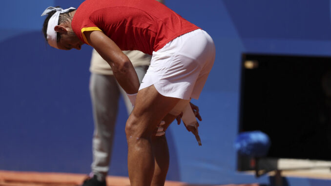 El tenista español Rafa Nadal se toca el muslo tras una jugada ante el serbio Novak Djokovic durante el partido celebrado en el marco de los Juegos Olímpicos de París, este lunes. EFE/ Juanjo Martín
