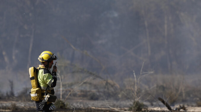 Fotografía de archivo de un bombero trabajando en una zona afectada por un incendio forestal declarado el pasado mes de mayo en Riba-roja de Túria (Valencia). EFE/Kai Försterling
