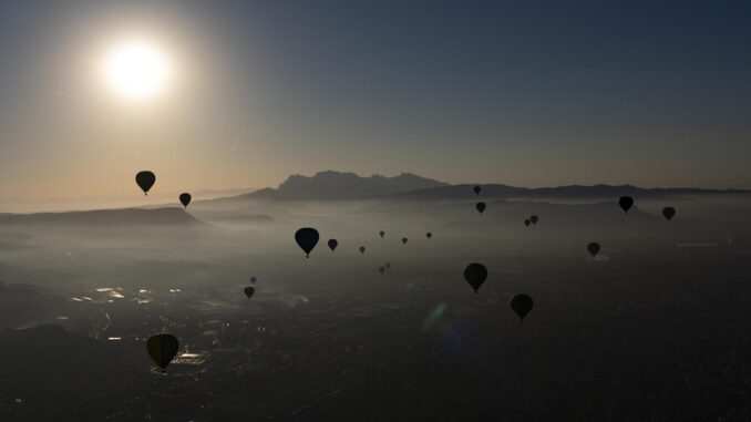 Imagen del amanecer hoy en Igualada (Barcelona) lleno de globos aerostáticos durante el vuelo simultáneo inaugural del European Balloon Festival. EFE/Siu Wu.
