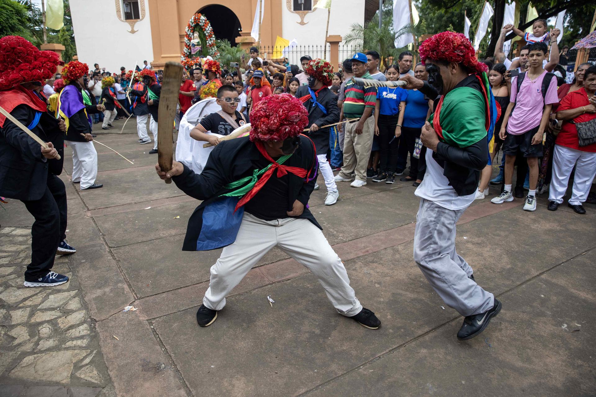 Personas participan del tradicional baile de Los Chinegros, en honor a Santa Ana, este viernes en Nindirí (Nicaragua). EFE/STR
