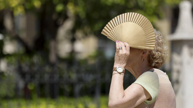 Una mujer se protege del sol con un abanico durante la mañana de este miércoles. EFE/Ana Escobar
