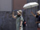 Dos turistas sen protegen del sol y del calor con un parasol durante la mañana de este martes en Valencia. EFE/Kai Försterling