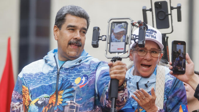 El presidente de Venezuela Nicolás Maduro (c) y su esposa Cilia Flores saludan a sus seguidores este jueves, en Caracas (Venezuela). EFE/ Miguel Gutiérrez
