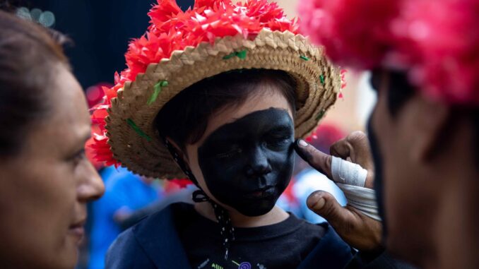 Un niño disfrazado participa del tradicional baile de Los Chinegros, en honor a Santa Ana, este viernes en Nindirí (Nicaragua). EFE/STR
