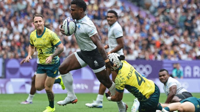 El jugador Jerry Tuwai, de Fiji, deja a trás al australiano durante el partido de semifinales que han jugado Fiji y Australia en el Stade de France en Saint Denis, Francia. EFE/EPA/CHRISTOPHE PETIT TESSON
