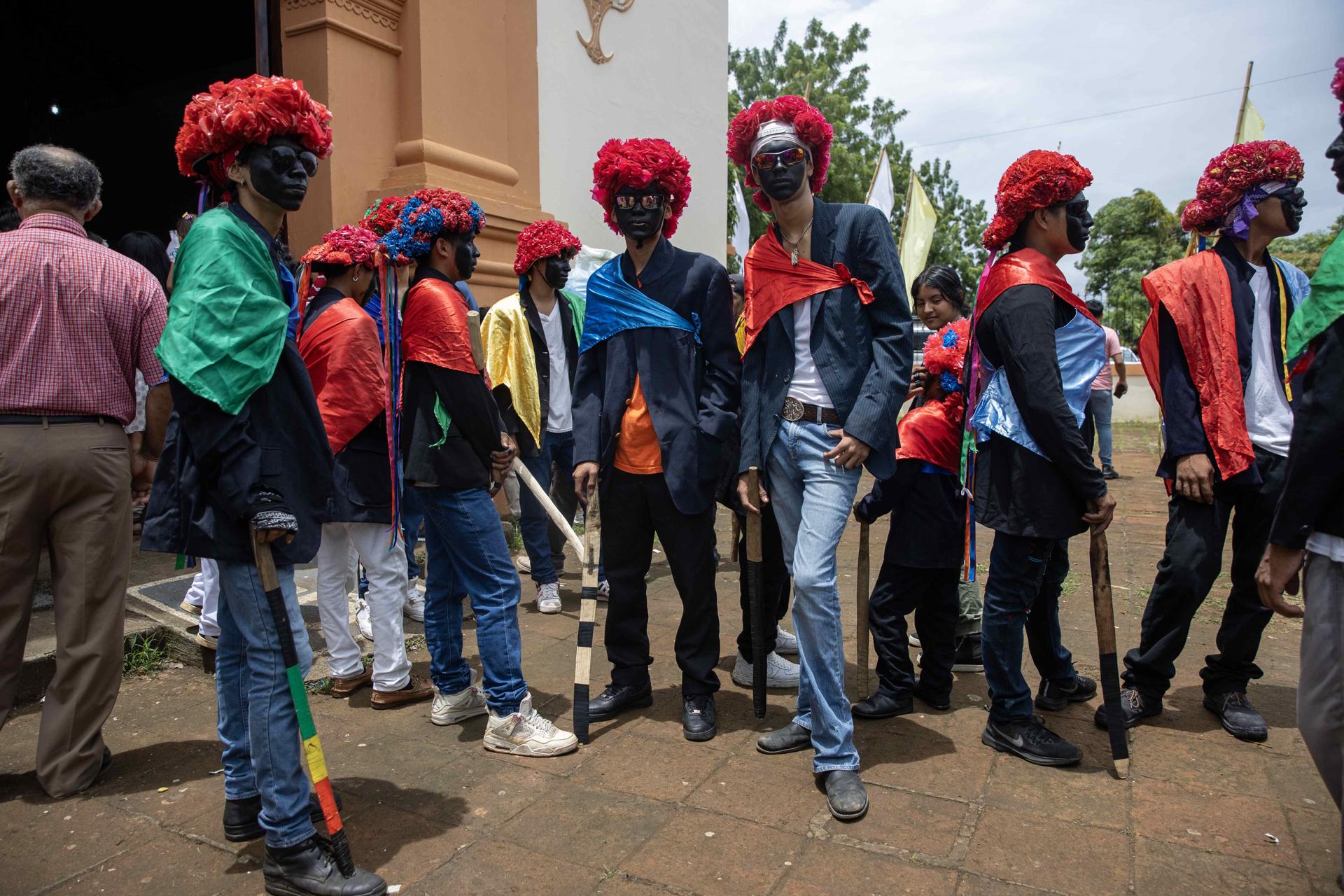 Personas disfrazadas posan previo al tradicional baile de Los Chinegros, en honor a Santa Ana, este viernes en Nindirí (Nicaragua). EFE/STR
