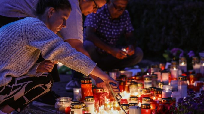 Imagen de 26 de agosto de 2024 de personas que encienden velas en el lugar del crimen en Solingen, Alemania. EFE/EPA/CHRISTOPHER NEUNDORF
