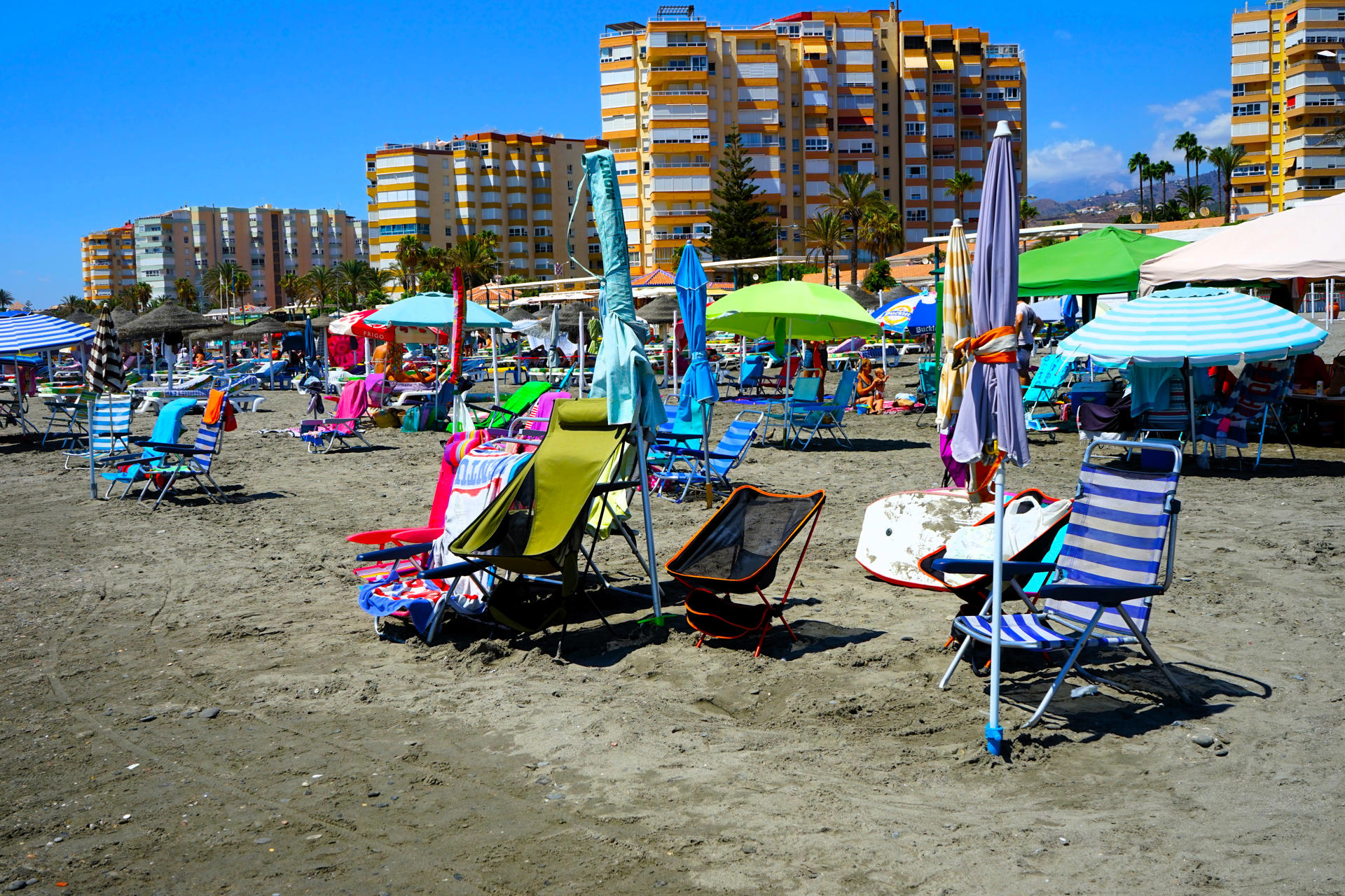 TORROX (MÁLAGA), 18/08/2024.- Tumbonas vacías y sombrillas plegadas en la playa de Torrox (Málaga), donde la Policía Local multa con hasta 300 euros a quien llega a la playa temprano para guardar sitio en primera línea y no regresan hasta que pasan muchas horas. Según ha informado a EFE el alcalde del municipio, Óscar Medina, esta medida ya ha afectado desde finales de julio a más de 50 personas, a quienes los agentes han requisado sus pertenencias. EFE/ María Alonso
