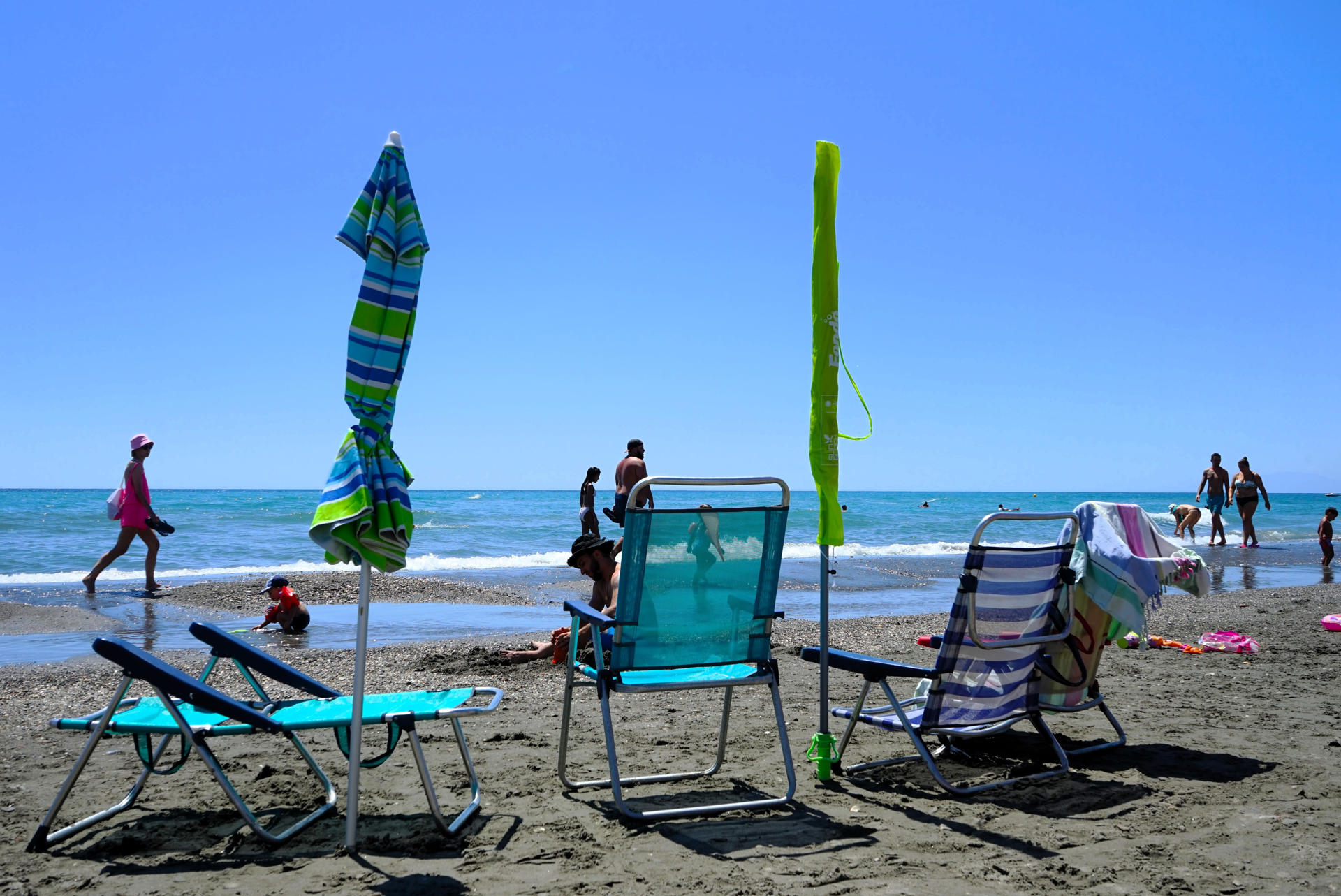 TORROX (MÁLAGA), 18/08/2024.- Tumbonas vacías y sombrillas plegadas en la playa de Torrox (Málaga), donde la Policía Local multa con hasta 300 euros a quien llega a la playa temprano para guardar sitio en primera línea y no regresan hasta que pasan muchas horas. Según ha informado a EFE el alcalde del municipio, Óscar Medina, esta medida ya ha afectado desde finales de julio a más de 50 personas, a quienes los agentes han requisado sus pertenencias. EFE/ María Alonso
