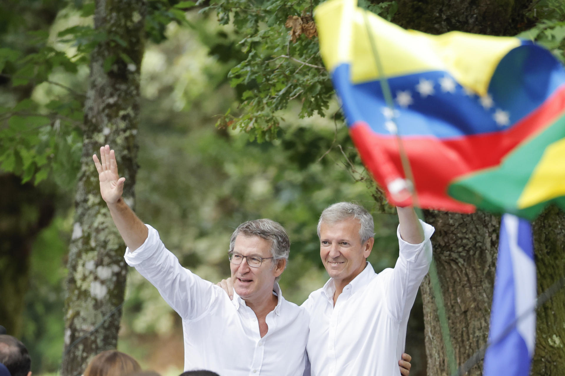 CerdEl líder del PP, Alberto Núñez Feijóo, acompañado del presidente de la Xunta, Alfonso Rueda, con banderas de países latinoamericanos durante un acto celebrado en Cerdedo-Cotobade este sábado con el que abre el curso político en Galicia. EFE/Lavandeira jr
