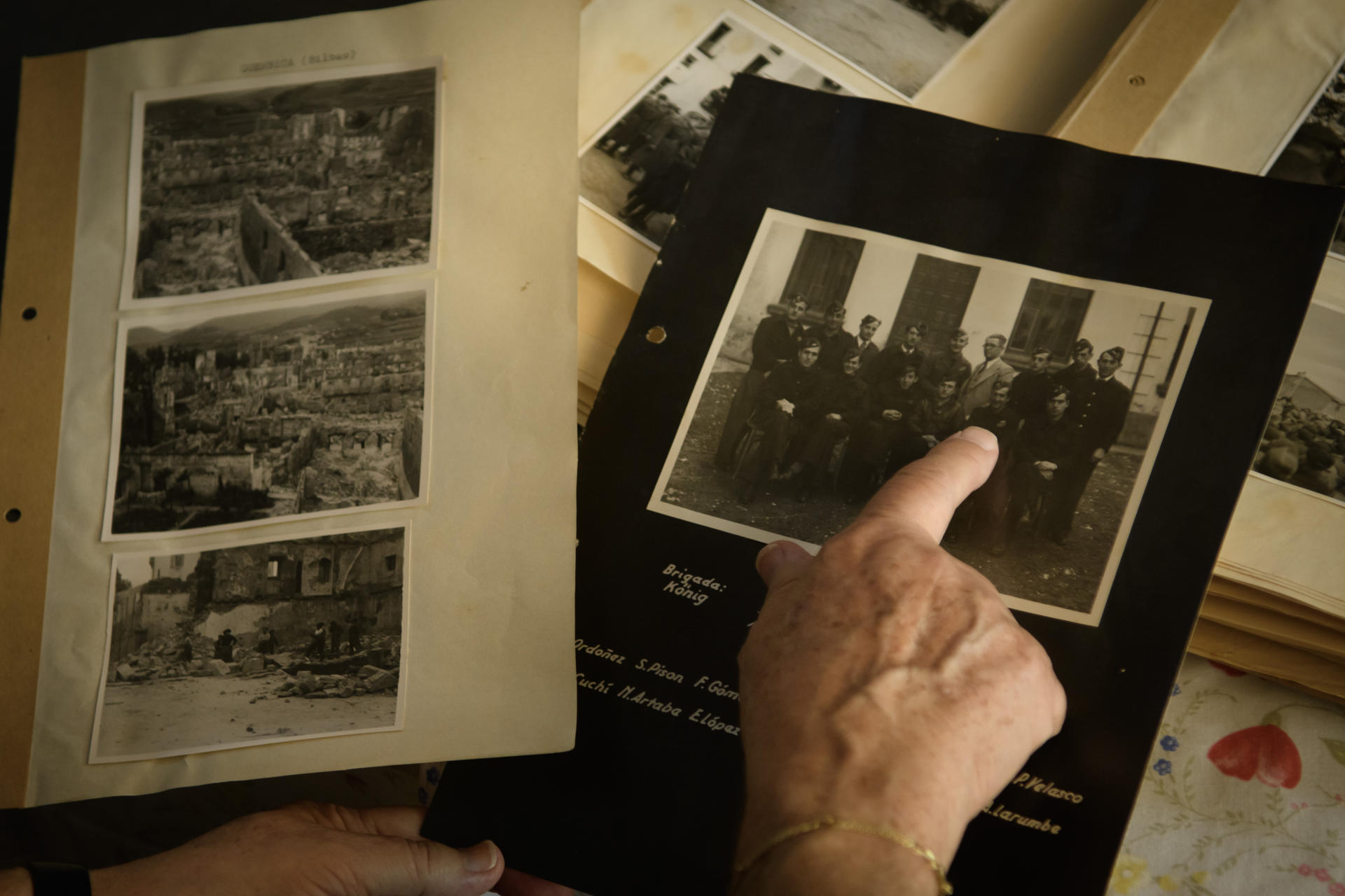 Trinidad Caro Pardo, vecina de Mairena del Aljarafe y maestra jubilada de 76 años, señala una foto en la que aparece su padre, el militar, fotógrafo, cartógrafo, topógrafo, delineante y dibujante sevillano Antonio Caro Serrano, fallecido en 1999 y quien, al declararse la Guerra Civil, con 18 años y por sus extraordinarias habilidades, fue requerido por la Legión Condor, con la que recorrió toda España. Conservó una serie de fotografías originales -de las que se desconoce si hay copia en archivos históricos militares- que el mismo hizo, entre ellas una decena de Guernica horas después de ser arrasada por la aviación alemana (i). EFE/ Raúl Caro.
