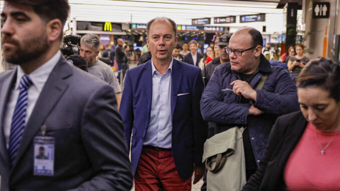 Nicolás Mangiarotti (c), encargado de negocios en la embajada de Argentina en Venezuela, llega al aeropuerto de Ezeiza (Buenos Aires) después de ser expulsado de Venezuela por el gobierno de Nicolás Maduro, este sábado. EFE/Juan Ignacio Roncoroni
