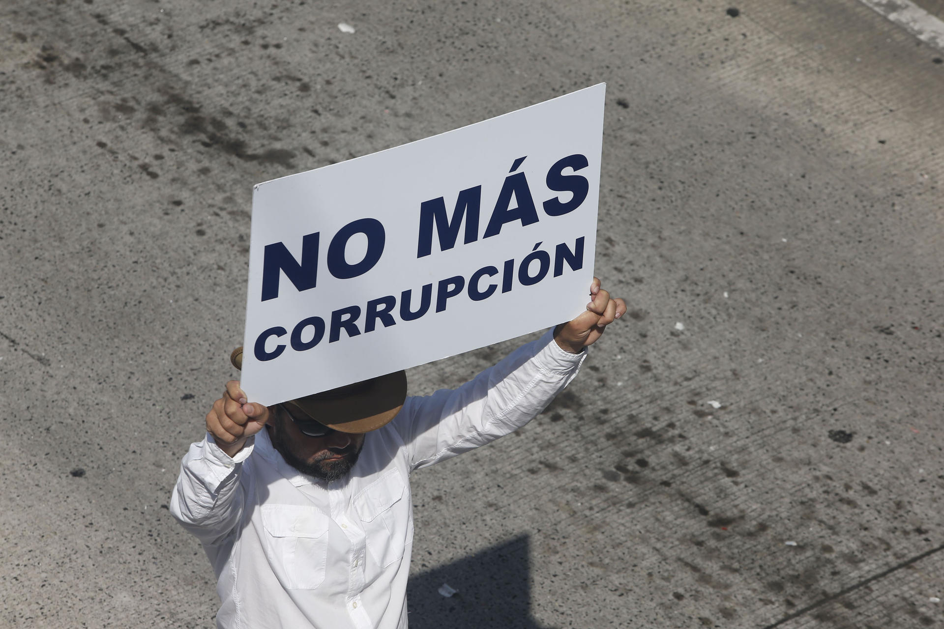 Un hombre sostiene un cartel durante una marcha este domingo en San Salvador (El Salvador). Centenares de personas protestaron este domingo en El Salvador contra el Gobierno de Nayib Bukele para exigir el cese delos atropellos a los derechos humanos, denunciar la falta de acciones para localizar a los desaparecidos y retrocesos en materia de género en una manifestación que coincidió con los actos de la Independencia de Centroamérica. EFE/Javier Aparicio
