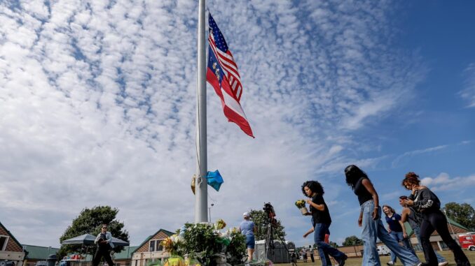 Los dolientes hacen una pausa en un monumento improvisado, un día después del tiroteo mortal en la escuela secundaria Apalachee en Winder, Georgia, EE. UU., el 5 de septiembre de 2024. EFE/EPA/Erik S. Lesser
