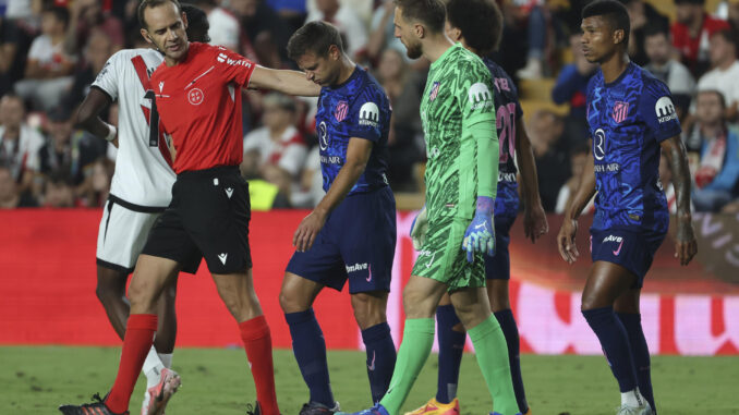 El defensa del Atlético de Madrid, César Azpilicueta (i), abandona el terreno de juego tras caer lesionado durante el encuentro correspondiente a la sexta jornada de Laliga EA Sportsen el estadio de Vallecas, en Madrid. EFE / Kiko Huesca.
