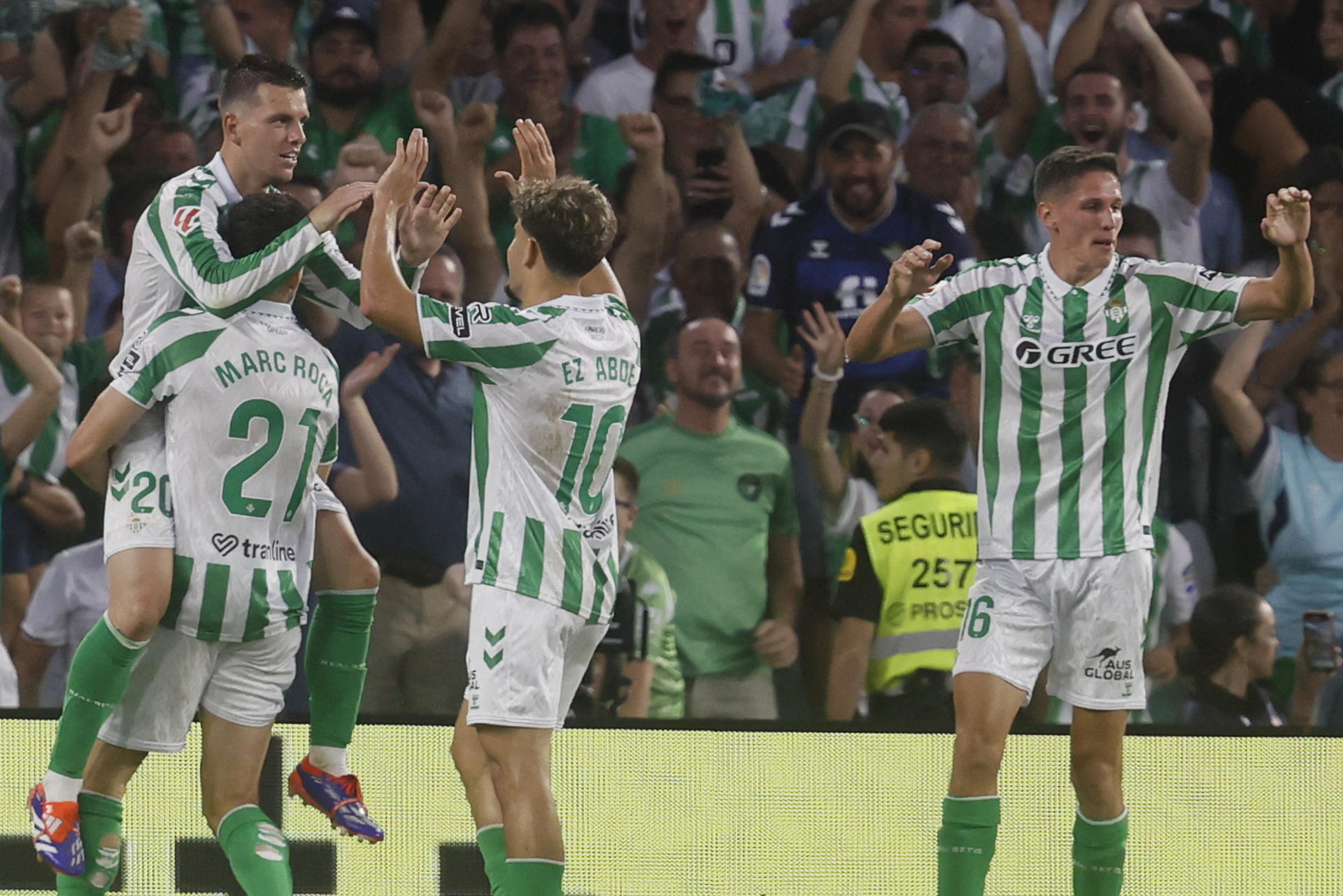 El centrocampista argentino del Betis, Giovani Lo Celso (i), celebra con sus compañeros el segundo gol del equipo andaluz durante el encuentro correspondiente a la tercera jornada de LaLiga que disputaron Betis y Getafe en el estadio Benito Villamarín de Sevilla. EFE/ José Manuel Vidal
