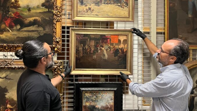 Dos conservadores de la Casa Colón con uno de los cuadros incautados. EFE. CABILDO DE GRAN CANARIA
