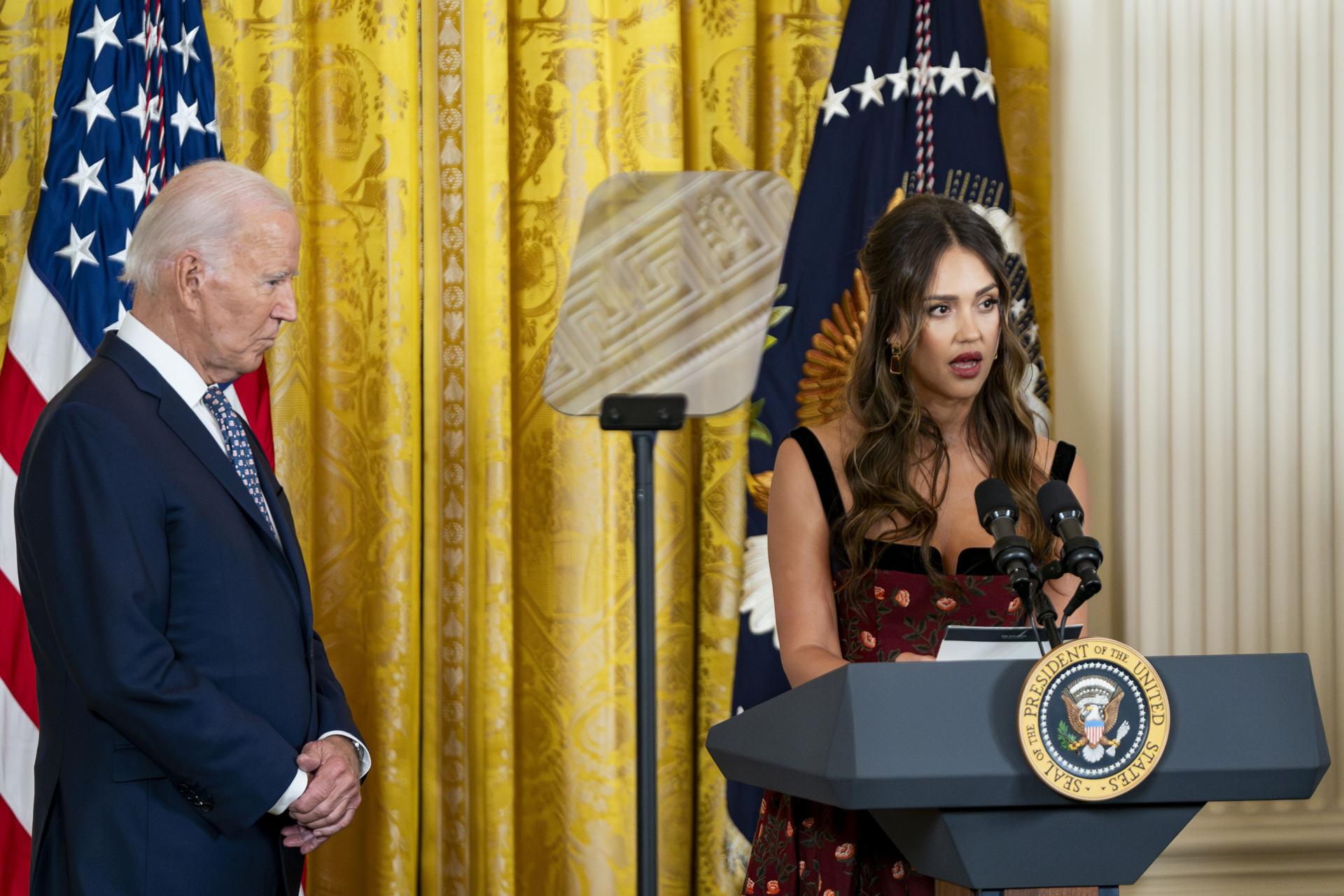 El presidente de Estados Unidos, Joe Biden (izq.), observa a la actriz y empresaria estadounidense Jessica Alba, quien habla durante una recepción en celebración del Mes de la Herencia Hispana en Washington, DC, el 18 de septiembre de 2024. EFE/BONNIE CASH/Pool
