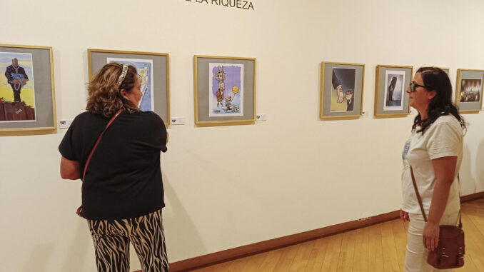 Dos mujeres visitan ‘Milmillonarios’, la exposición central de la XXXI Muestra Internacional de las Artes del Humor de Alcalá de Henares, en la que se representa a través de viñetas y el doble sentido la codicia, la opulencia, la avaricia y el descaro de los más pudientes. EFE/ Guilllermo Martínez
