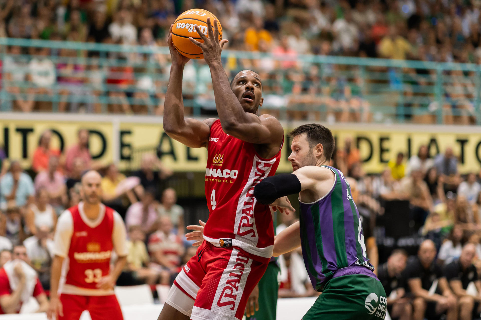 El ala-pivot estadounidense del AS Mónaco, Jaron Blossomgame (i), es defendido por el escolta estadounidense del Unicaja, Tyler Kalinoski (d), durante el encuentro correspondiente al Torneo Costa del Sol disputado esta tarde en el Pabellón El Limón de Alhaurín de la Torre. EFE/Carlos Díaz.
