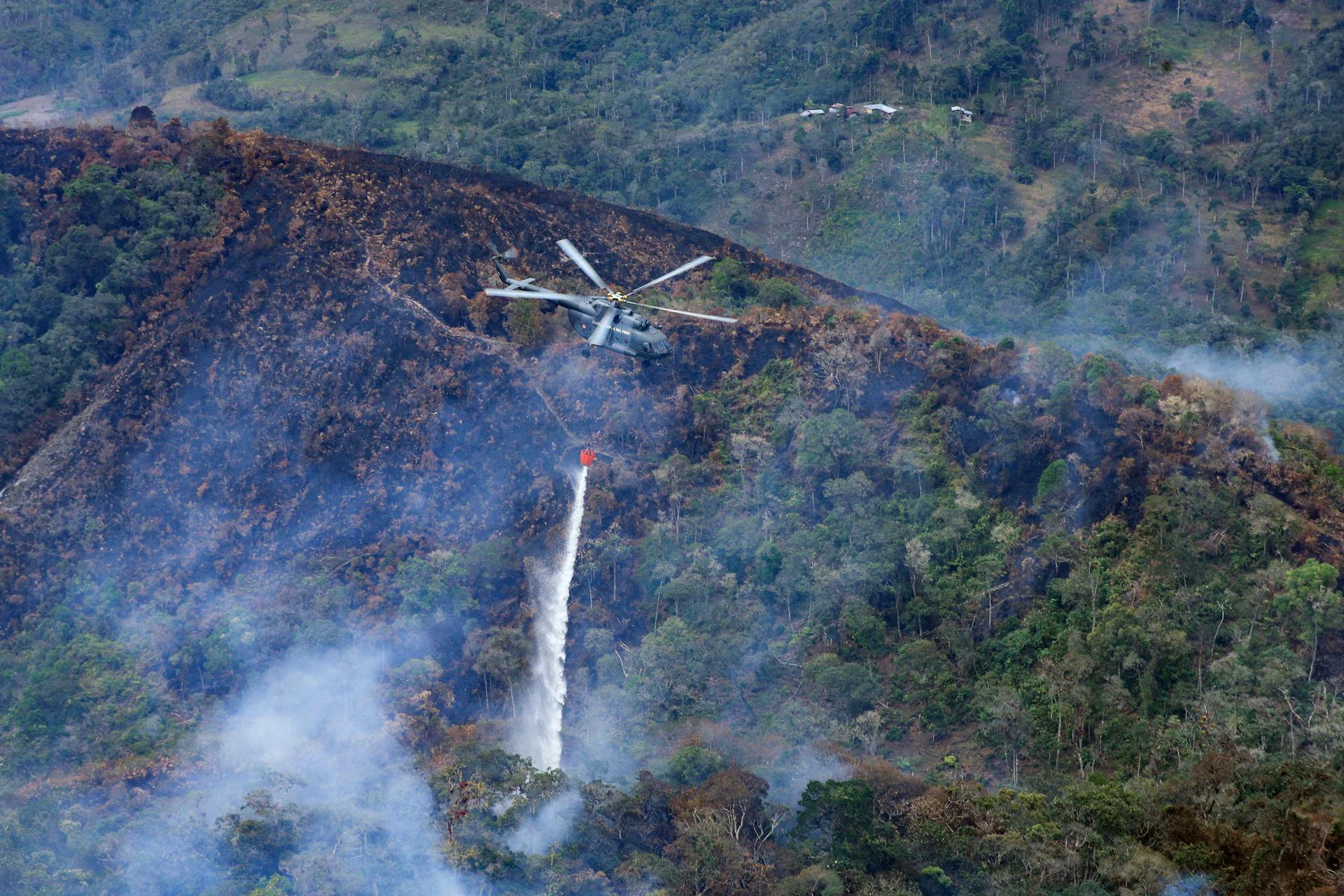 Fotografía cedida por la presidencia de Perú del desplazamiento de un helicóptero con sistema Bambi bucket en la zona de la Florida en Amazonas. EFE/ Presidencia de Perú
