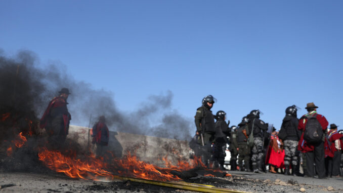 Indígenas bloquean una vía incinerando escombros durante una protesta este lunes en la ciudad de El Alto (Bolivia). Los indígenas llamados 'ponchos rojos' del altiplano de Bolivia, iniciaron este lunes un bloqueo de caminos para exigir la renuncia del presidente Luis Arce y del vicepresidente David Choquehuanca, por la falta de dólares y combustible además de acusarles de promover la división de las organizaciones sociales. EFE/Luis Gandarillas
