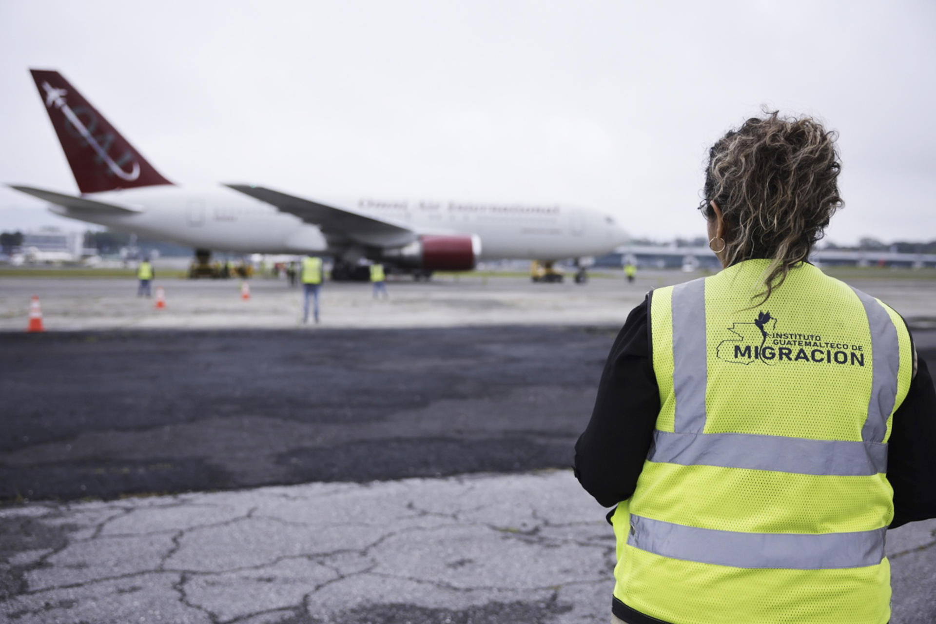 Fotografía cedida por el Gobierno de Guatemala de una trabajadora de migración observando el avión que transporta a los 135 nicaragüenses liberados este jueves, en el Aeropuerto Internacional La Aurora, en la Ciudad de Guatemala (Guatemala). EFE/ Gobierno De Guatemala
