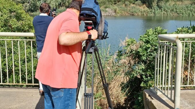 Imagen de junio de 2022 de unos reporteros en la dársena del Guadalquivir a su paso por Sevilla, donde fue encontrado el cadáver de una mujer cuya desaparición fue denunciada el pasado 4 de mayo. EFE/Juan Chicano
