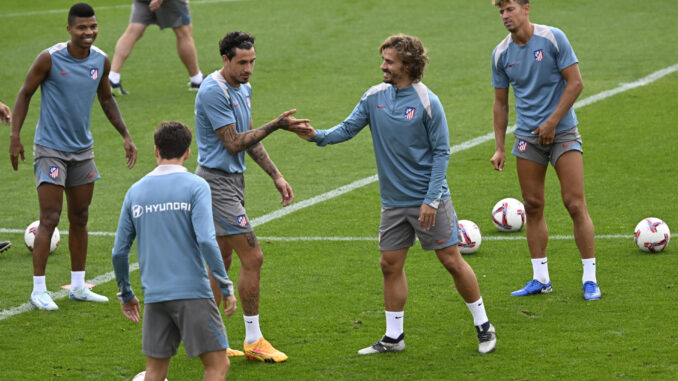 Griezmann y Giménez se saludan, junto a Llorente y Reinildo, durante el entrenamiento de este sábado.-EFE/ Víctor Lerena
