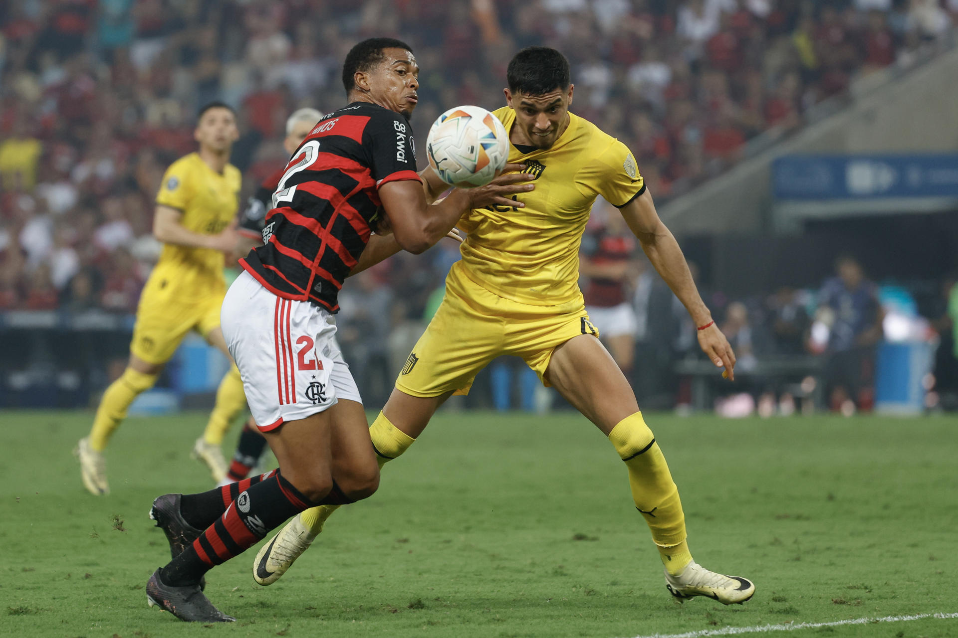 Carlos Moisés de Lima (i) de Flamengo disputa un balón con Guzmán Rodríguez de Peñarol en el partido de ida de cuartos de final de la Copa Libertadores. EFE/ Antonio Lacerda
