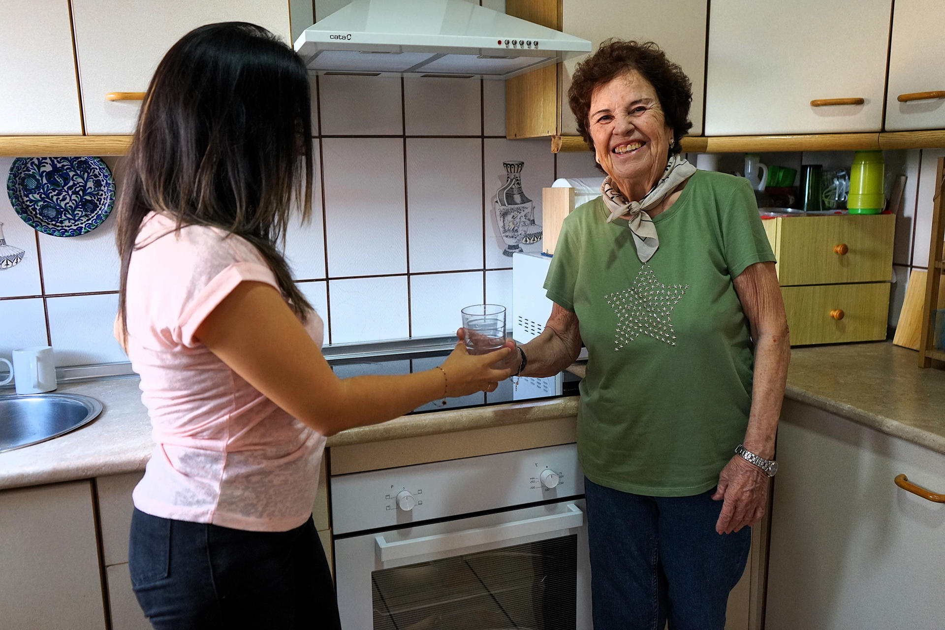 Carmen, una malagueña de 87 años, y Pamela, una estudiante de máster de Ecuador, dos mujeres que comparten piso gracias a una iniciativa de la Universidad de Málaga que ofrece a los jóvenes una habitación gratis a cambio de que hagan compañía a los mayores, les acompañen al médico o les compren medicamentos, posan para EFE. EFE/María Alonso
