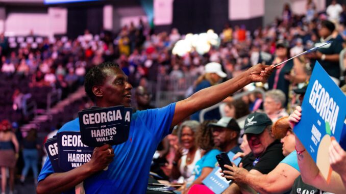 Voluntarios afines a la vicepresidenta estadounidense y candidata presidencial demócrata Kamala Harris entregan carteles a sus partidarios para sostener durante un mitin de campaña en el Enmarket Arena en Savannah, en el estado de Georgia, EE. UU., el 29 de agosto de 2024. EFE/EPA/Hunter D. Cone
