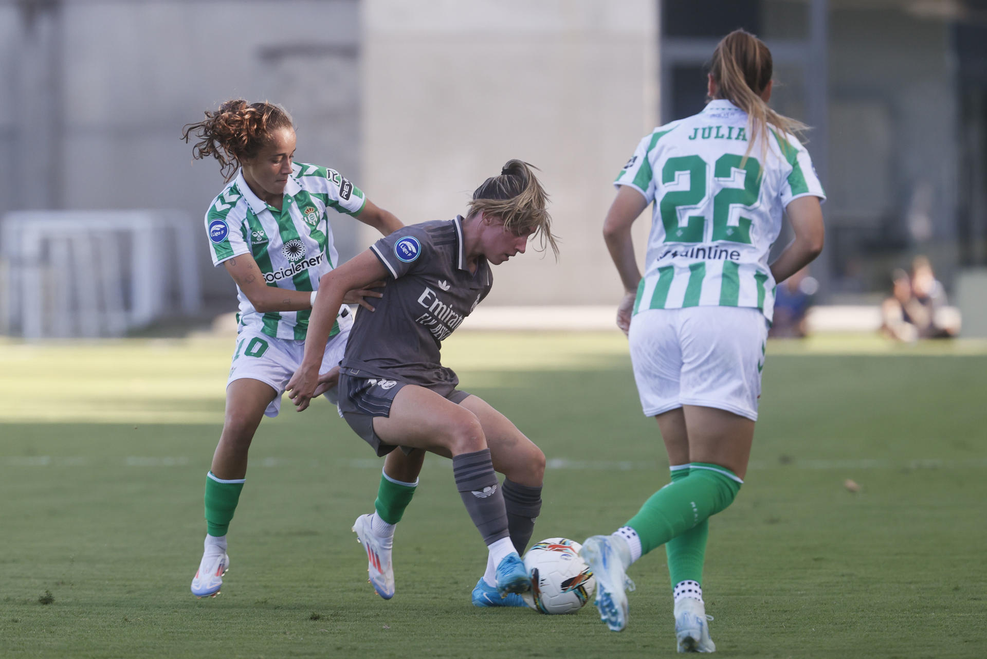 La centrocampista del Betis Rosa Márquez (i) disputa un balón con la delantera del Real Madrid Eva Navarro (c) durante el encuentro de Primera División femenina entre Real Betis Balompié y Real Madrid, este sábado en la Ciudad Deportiva Luis de Sol de Sevilla. EFE/ José Manuel Vidal
