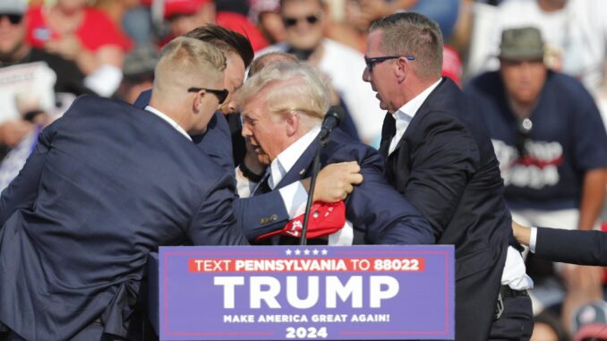 Fotografía de archivo del expresidente de EE.UU., Donald Trump mientras era evacuado de un mitin en Butler Pensilvania (EE.UU.) después de que se escucharan tiros en lugar que lo alcanzaron a herir en la oreja derecha. EFE/EPA/DAVID MAXWELL
