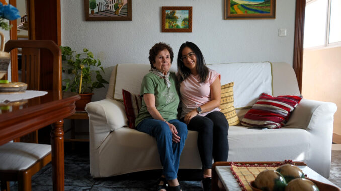 Carmen, una malagueña de 87 años, y Pamela, una estudiante de máster de Ecuador, dos mujeres que comparten piso gracias a una iniciativa de la Universidad de Málaga que ofrece a los jóvenes una habitación gratis a cambio de que hagan compañía a los mayores, les acompañen al médico o les compren medicamentos, posan para EFE. EFE/María Alonso
