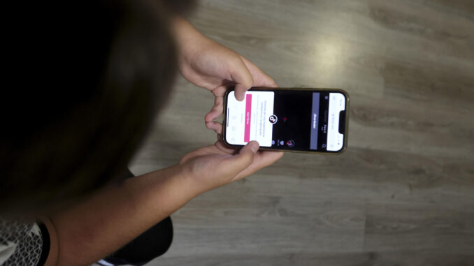 Una joven consulta su teléfono móvil en una imagen de archivo. EFE/ J.M. García
