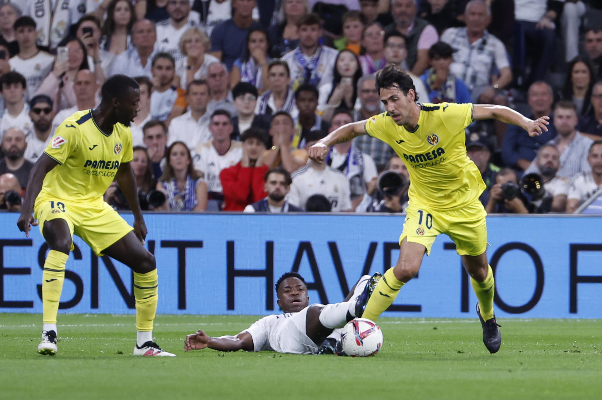 El delantero brasileño del Real Madrid Vinicius jr. ante el centrocampista del Villarreal Daniel Parejo (d) durante el partido de la jornada 9 entre Real Madrid y Villarreal en el estadio Santiago Bernabéu. EFE/Javier Lizón
