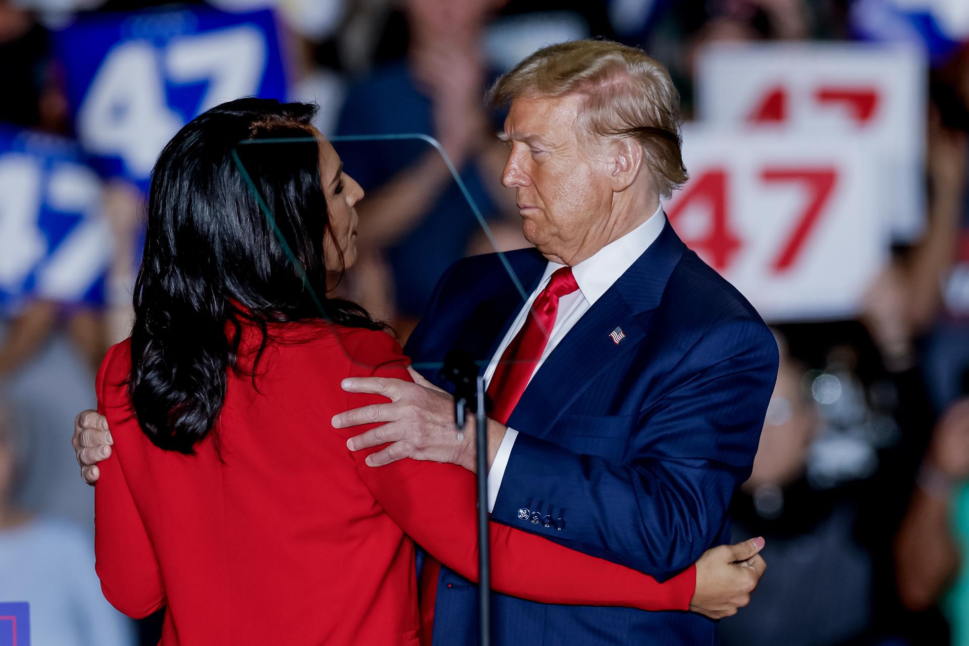 El expresidente estadounidense y candidato presidencial republicano Donald Trump (d) abraza a la exrepresentante demócrata de Hawái Tulsi Gabbard (i) en un mitin de campaña en Greensboro, Carolina del Norte, EE.UU., el 22 de octubre de 2024. EFE/ERIK S. MENOR
