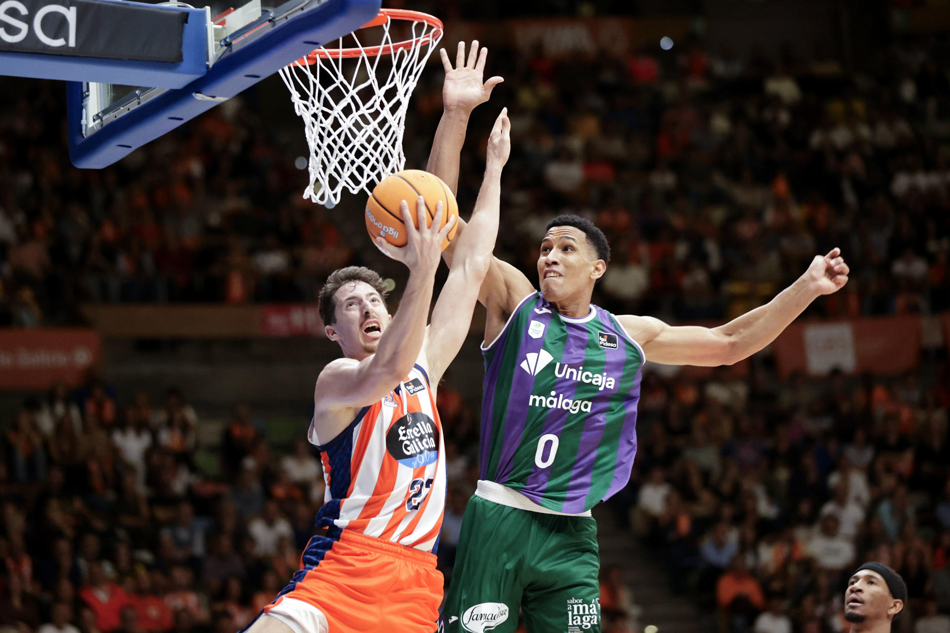 El escolta del Coruña Aleix Font (i) entra a canasta ante Kameron Taylor, de Unicaja, durante el encuentro correspondiente a la cuarta jornada de la Liga Endesa que Leyma Coruña y Unicaja Málaga disputan este sábado en el Coliseum de A Coruña. EFE/Cabalar
