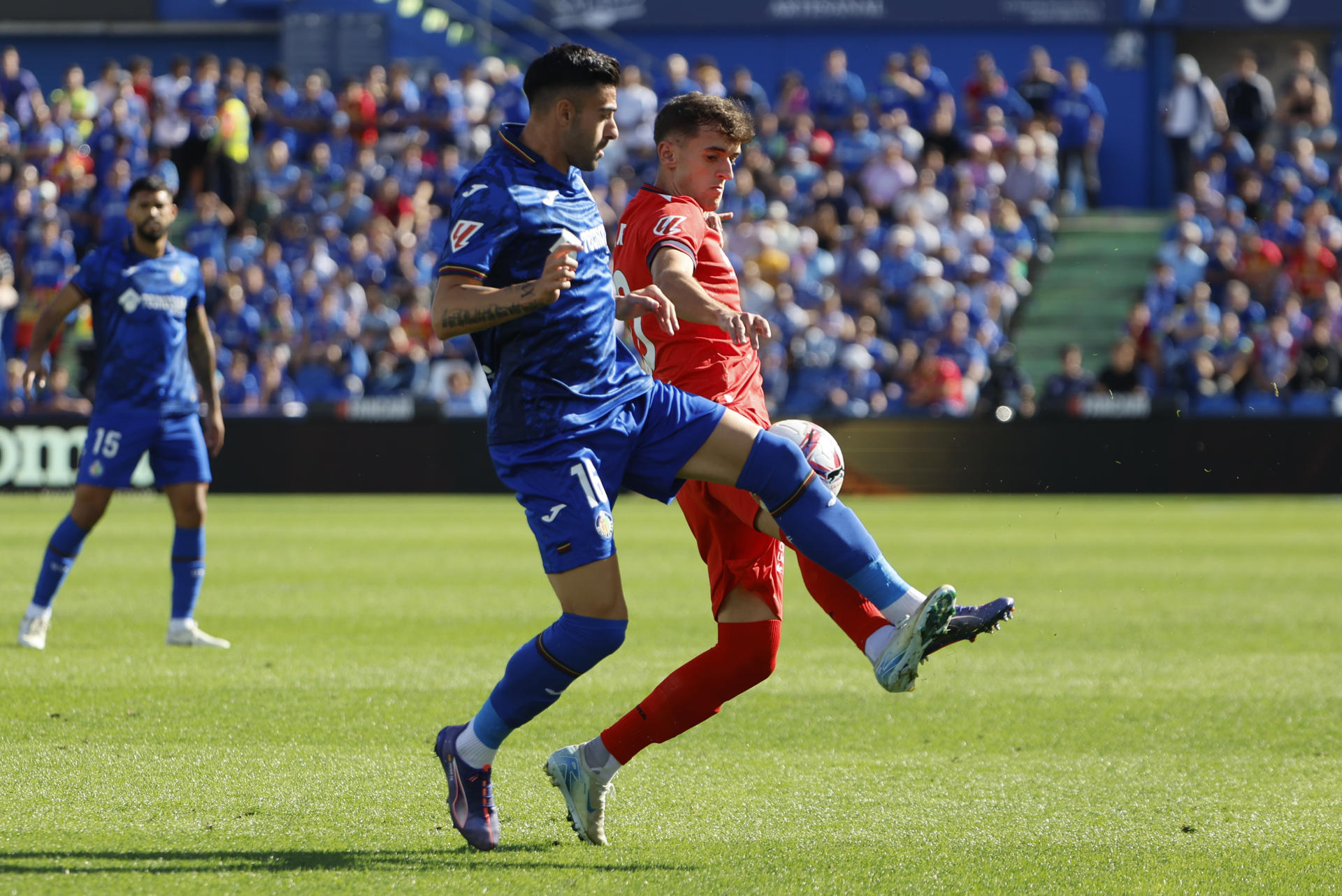 El defensa del Getafe Diego Rico (i) lucha un balón con el centrocampista del Osasuna Aimar Oroz durante el partido correspondiente a la novena jornada de LaLiga EA Sports disputado esta tarde en el Estadio Coliseum de Getafe. EFE/Sergio Pérez
