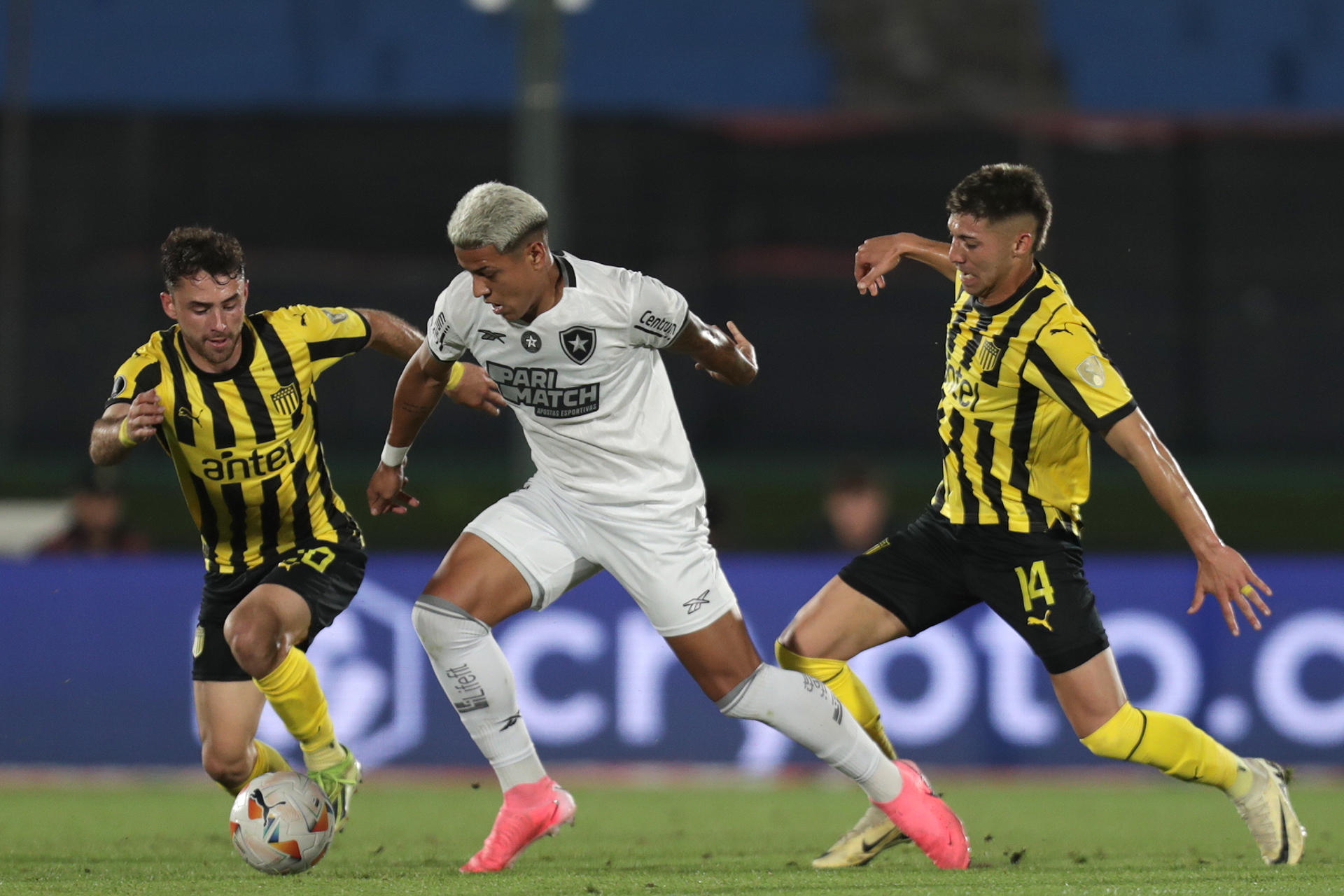 Pedro Milans (i) y Sergio García (d) de Peñarol disputan el balón con Matheus Martins de Botafogo en un partido de las semifinales de la Copa Libertadores. EFE/ Sofia Torres
