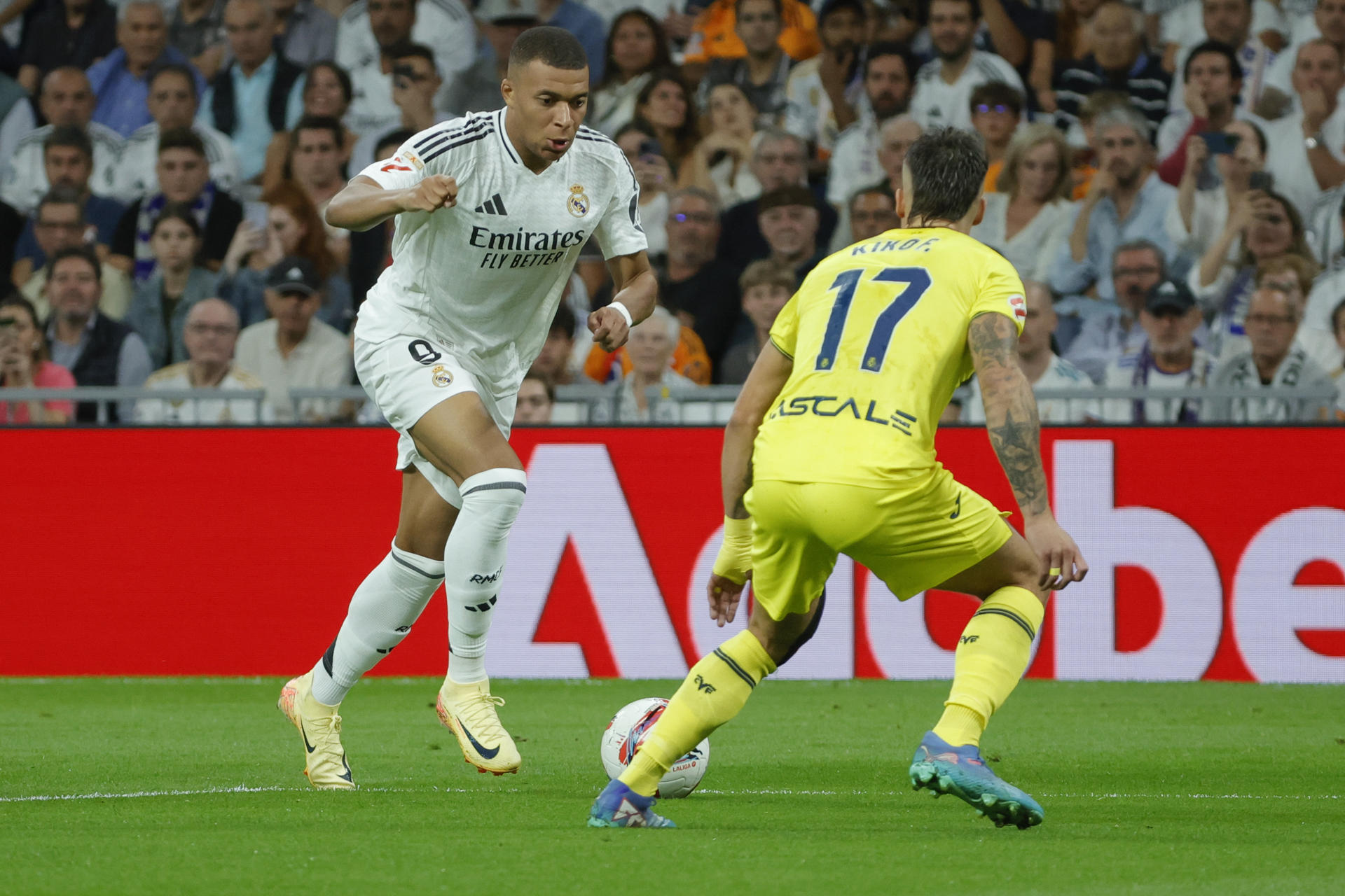 El delantero francés del Real Madrid Kylian Mbappé (i) ante el defensa del Villarreal Francisco Femenía Far durante el partido de la jornada 9 de Liga entre Real Madrid y Villarreal en el estadio Santiago Bernabéu. EFE/Zipi Aragón
