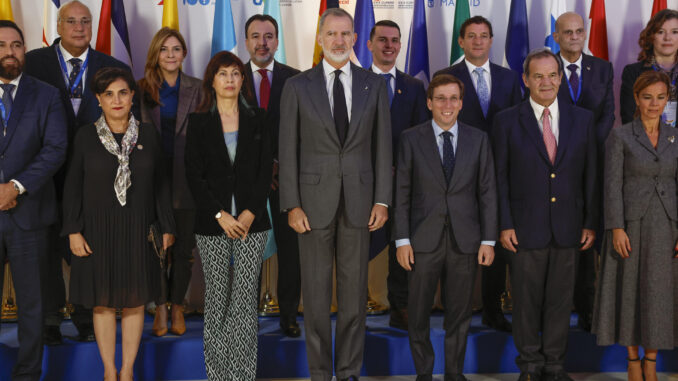 El rey Felipe VI (C), acompañado por la ministra de Igualdad, Ana Redondo (3i), y el alcalde de Madrid, José Luis Martínez-Almeida (3d), posa para una foto de grupo mientras asiste al I Encuentro de Ciudades Iberoamericanas, este jueves, en un hotel madrileño. EFE/ Chema Moya
