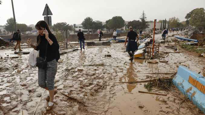 Una mujer camina entre el lodo acumulado por las intensas lluvias de la fuerte dana que afecta especialmente el sur y el este de la península ibérica, este miércoles en Picaña (Valencia). EFE/Biel Aliño
