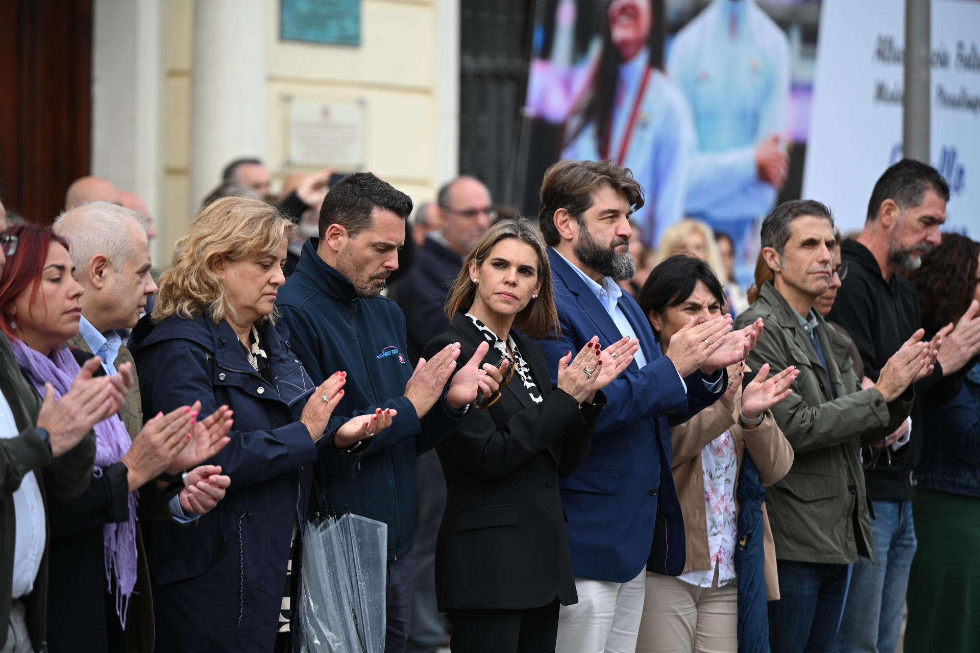 La alcaldesa de Alcalá de Henares, Judit Piquet (c) y el presidente de la Asociación Gremial del Taxi de Alcalá de Henares,José Antonio García (c-i) tras el minuto de silencio de este jueves por el asesinato de un taxista de la localidad. EFE/ Fernando Villar
