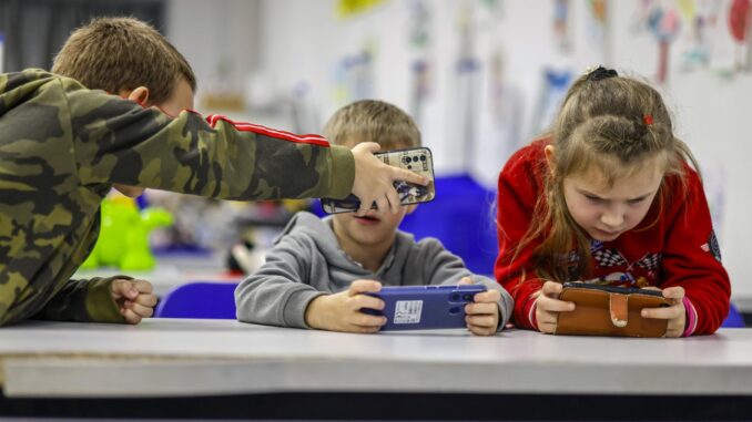 Imagen de archivo de varios niños con teléfonos móviles. EFE/EPA/HANNIBAL HANSCHKE
