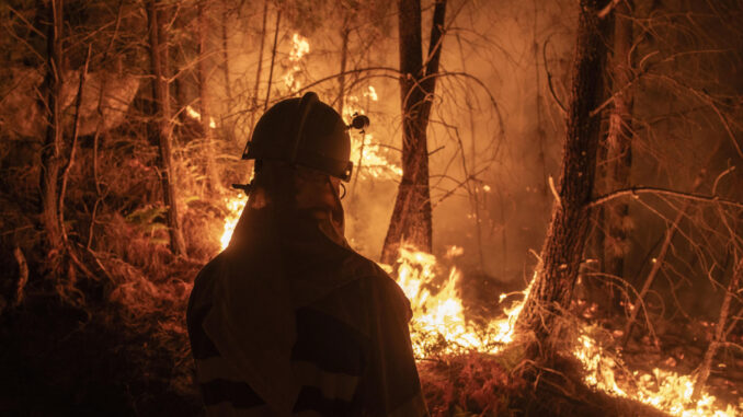 Un bombero forestal observa las llamas mientras trabaja en las labores de extinción de un incendio forestal, en una fotografía de archivo. EFE/ Brais Lorenzo
