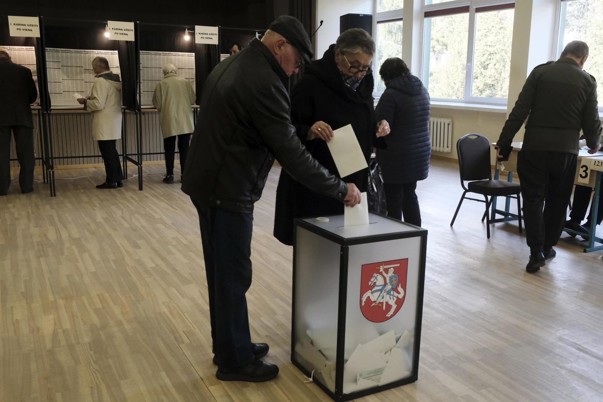 La gente emite sus votos durante la primera vuelta de las elecciones parlamentarias en Utena, Lituania, el 13 de octubre de 2024. EFE/Valda Kalnina
