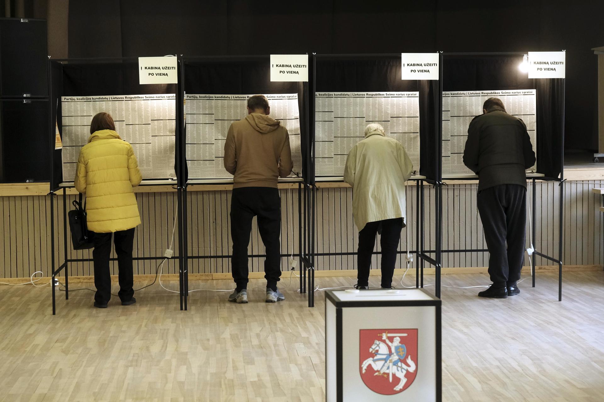 La gente emite sus votos durante la primera vuelta de las elecciones parlamentarias en Utena, Lituania, el 13 de octubre de 2024. EFE/Valda Kalnina
